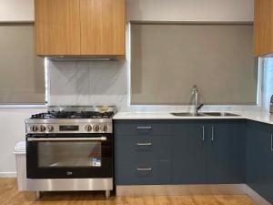 a kitchen with a stove and a sink at Nest & Rest in Westcourt