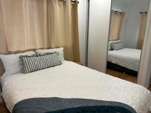 a bedroom with a large bed and a mirror at Nest & Rest in Westcourt