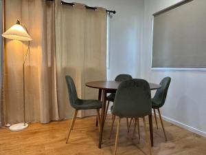 a table and chairs in a room with a projector screen at Nest & Rest in Westcourt