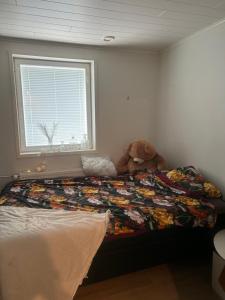 a bedroom with a bed with a teddy bear on it at Kolmio lähellä palveluita in Tampere