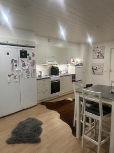 a kitchen with a table and a white refrigerator at Kolmio lähellä palveluita in Tampere