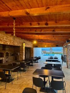 a dining room with tables and chairs and a brick wall at Bran Apartments in Star Dojran