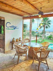 a patio with a table and chairs and a pool at B&B La Nava Suites in Mojácar