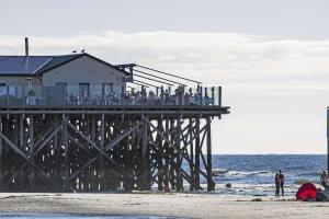 a group of people standing on a pier on the beach at Doppelhaushaelfte-Luette-Sprotte in Böhl