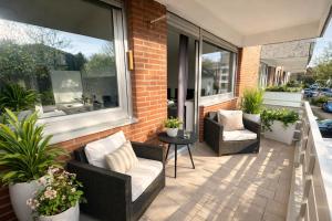 a patio with two chairs and a table and windows at Pulheim Living 4 in Pulheim