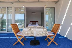 a bedroom with a bed with a table and two chairs at Vila Bliss in Ksamil
