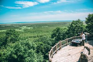 a man taking a picture of the view from a wooden deck at Kushiro Prince Hotel in Kushiro