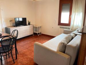 a living room with a couch and a tv and a table at Apartamento Uno in Guadalaviar