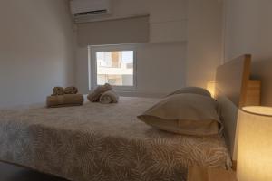 a bedroom with a bed with two pillows and a window at Casa Berardo in Megara