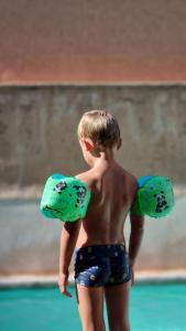 a young boy standing in a pool holding two balls at Tagadert Lodge in Oumnas +30 photos