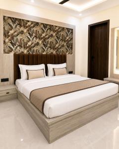a bedroom with a large bed with a wooden headboard at Hotel La Serene in Agra