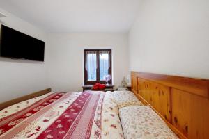 a bedroom with a bed and a television on the wall at L'archetto Valle d'Aosta in La Salle