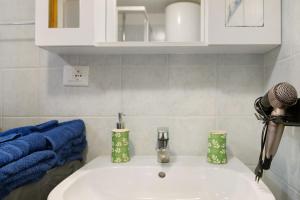 a bathroom with a white sink and blue towels at L'archetto Valle d'Aosta in La Salle