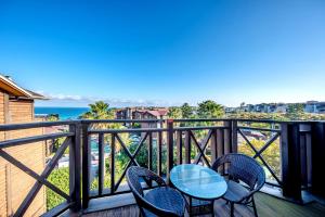 a table and chairs on a balcony with the ocean at Dyne Resort in Jeju