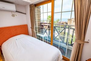 a bedroom with a bed and a large window at Dyne Resort in Jeju