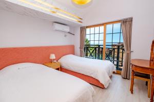 a bedroom with two beds and a desk and a window at Dyne Resort in Jeju