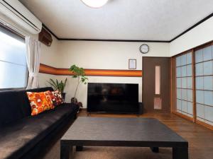 a living room with a couch and a coffee table at Haraya in Nakatsugawa