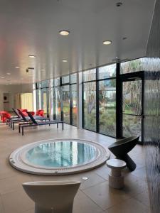 a large room with a swimming pool in a building at Novotel Le Havre Centre Gare in Le Havre