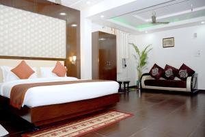 a bedroom with a large bed and a couch at The Vaishnavi Hotel , Buxar Bihar in Buxar