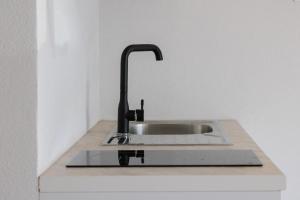 a kitchen sink with a black faucet on a counter at Vila Bliss in Ksamil +57 photos