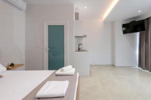 a white room with a bed with two towels on it at Vila Bliss in Ksamil