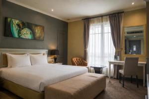 a hotel room with a bed and a desk and a window at Hotel Dafam Semarang in Semarang +56 photos