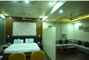 a bedroom with a large bed and a couch at The Vaishnavi Hotel , Buxar Bihar in Buxar