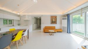 a kitchen and living room with a table and yellow chairs at Chuncheon Happysday Pet-Friendly Pension in Chuncheon