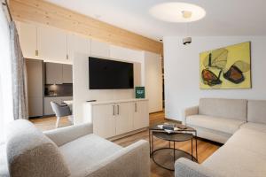 a living room with a couch and a flat screen tv at Aparthotel Saladina in Gaschurn