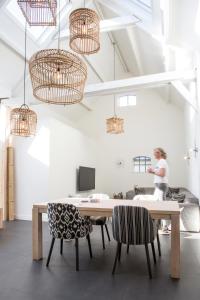 a woman in a room with a table and chairs at Bed & Bike De Dorsvloer in Domburg