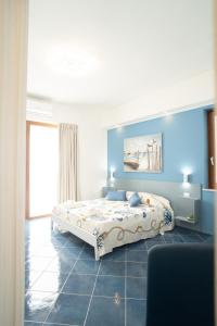 ein Schlafzimmer mit einem Bett und einer blauen Wand in der Unterkunft Affittacamere Iside in Sapri