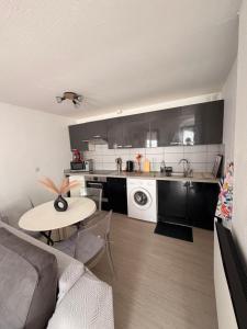 a kitchen with a couch and a table in a room at Studio centre du village in Tende