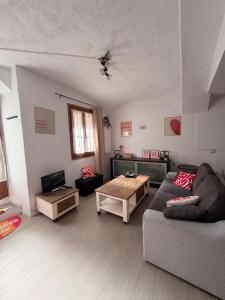 a living room with a couch and a table at Studio centre du village in Tende