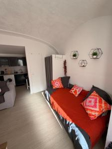 a bedroom with a bed with red sheets and pillows at Studio centre du village in Tende