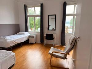 a room with two beds and a chair in it at B&B Carl XII in Ed