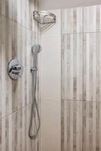 a shower with a shower head on a wall at Villa Alpina Borsec in Borsec +19 photos