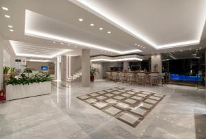 a lobby with tables and chairs in a building at Creta Palm Resort Hotel & Apartments in Stalos +62 photos