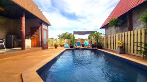 a swimming pool in a yard with two blue chairs at Villa Ayutthaya, Private Pool Near Kantiang Beach in Ko Lanta