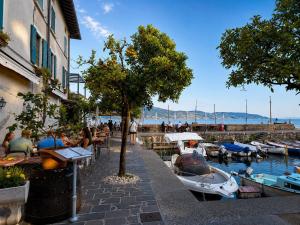 a group of people sitting at tables near a marina at SAGGEZZA Villa di GARGNANO in Gargnano