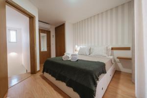 a bedroom with a bed with two towels on it at Houses São Pedro in São João da Pesqueira