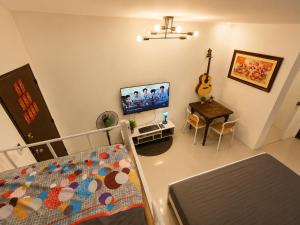 ein Schlafzimmer mit Bett, Fernseher und Tisch in der Unterkunft Harmony Villa in Tanza