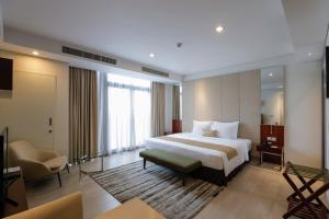 a hotel room with a bed and a chair at SILA Urban Living in Ho Chi Minh City