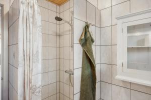 a shower with a green shower curtain in a bathroom at Lærke-huset in Bindslev +19 photos