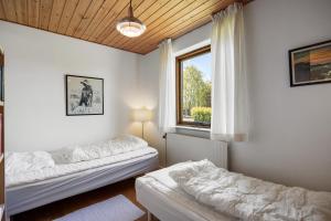a living room with two beds and a window at Lærke-huset in Bindslev