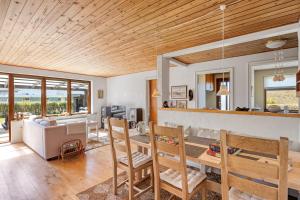 a kitchen and living room with wooden ceilings at Lærke-huset in Bindslev