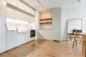 a kitchen with white cabinets and a table with chairs at Dalia Residence - Boutique Apartment in Sofia +12 photos