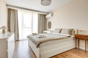 a white bedroom with a bed and a window at Dalia Residence - Boutique Apartment in Sofia