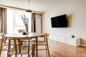 a living room with a table and chairs and a tv at Dalia Residence - Boutique Apartment in Sofia
