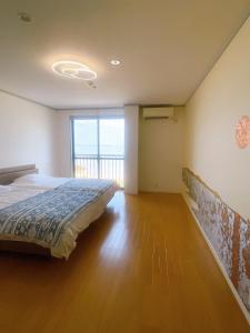 a bedroom with a bed and a large window at HOJO Brewing & Stays in Hōjō