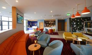 a waiting room with couches and tables and chairs at Travelodge Plus Galway in Galway